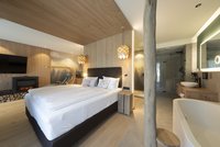 [Translate to english:] Panorama-Wellnesssuite - Badewanne neben Doppelbett