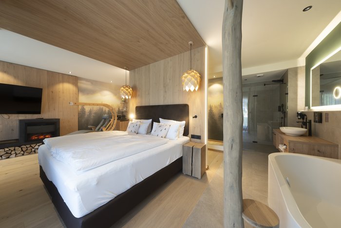 [Translate to english:] Panorama-Wellnesssuite - Badewanne neben Doppelbett