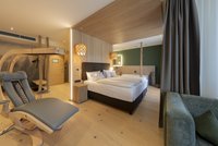 [Translate to english:] Panorama-Wellnesssuite - Infrarotliege neben Doppelbett