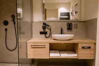 [Translate to english:] Waldwipfel Juniorsuite Badezimmer mit Waschtisch und Dusche