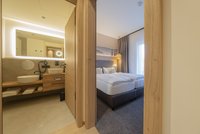 [Translate to english:] Baumhaus Familiensuite - Badezimmer und Schlafzimmer